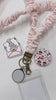 Interchangeable Andi Lanyard with floral fabric design and interchangeable attachment disc for compatible badge toppers.